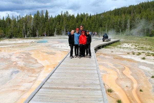 Family hiking around Old Faithful in Yellowstone National Park in Wyoming